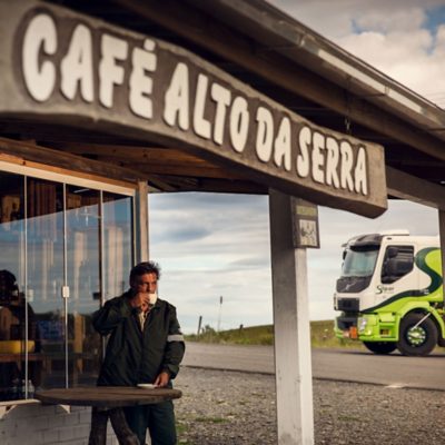 El conductor se sienta fuera de un café y se toma un descanso