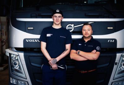 En tekniker och en servicemarknadschef framför en Volvo på en av våra verkstäder.