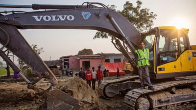 Un homme debout sur un engin de chantier Volvo | Groupe Volvo