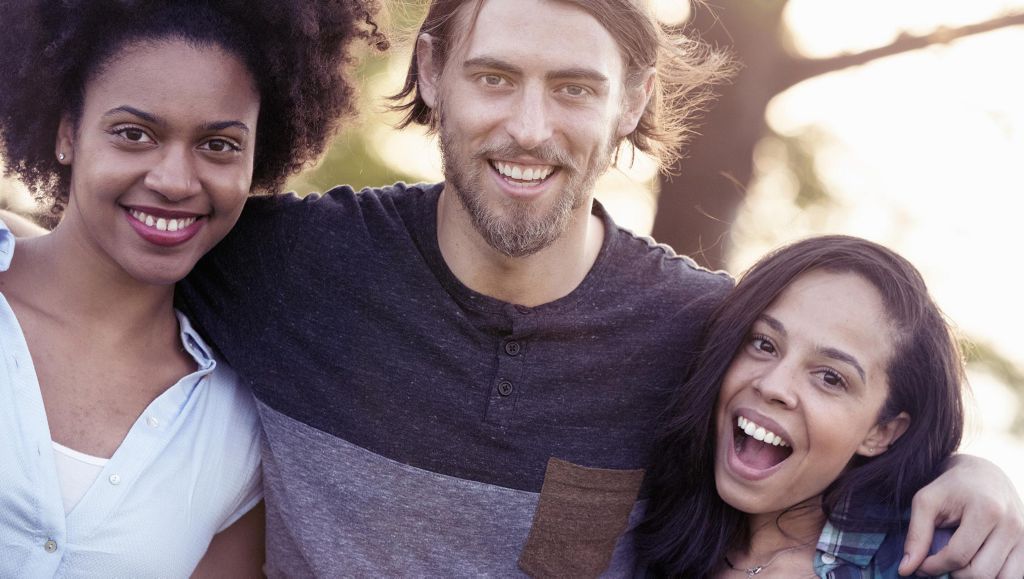 Two women and one man smiling in to the camera