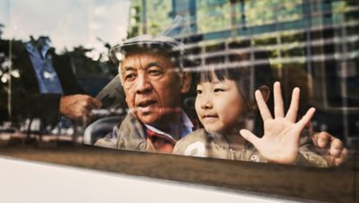 Hombre y niña en la ventanilla de un autobús