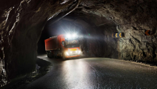 Red autonomous Volvo truck driving in a tunnel