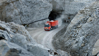 Red autonomous Volvo FH truck driving in a quarry