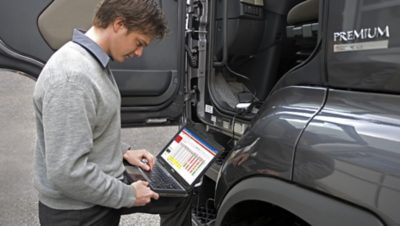 En man med en bärbar dator uppdaterar programvaran Informax i Renault lastbil | Volvokoncernen