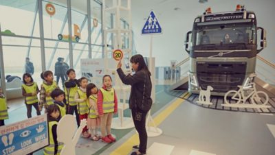 Kobieta uczy dzieci zasad ruchu drogowego I Volvo Group