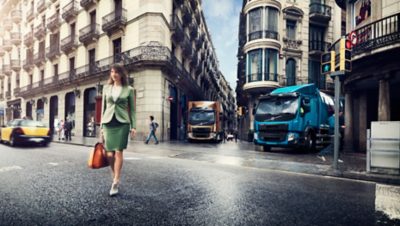 Two Volvo trucks waiting for the trafficlight to turn green in a crossing