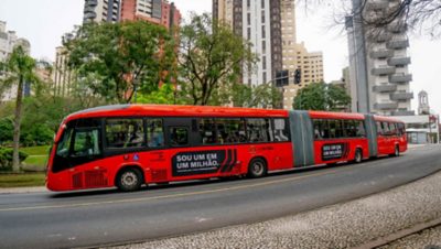 Red Volvo bus with eight wheel sets in Curitibia, Brazil