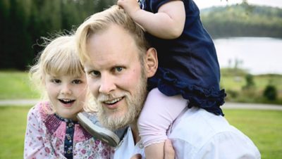 Volvo Group employee carrying his two kids