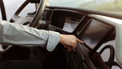 Main tendue vers le tableau de bord dans l'habitacle conducteur