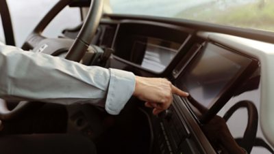 Dłoń wskazująca na ekran w kabinie kierowcy autokaru