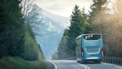 Buss som färdas på en väg som leder genom ett bergspass