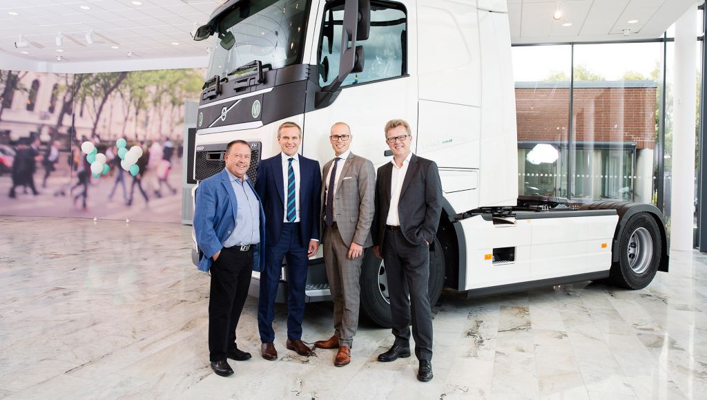 4 persons in front of a Volvo truck