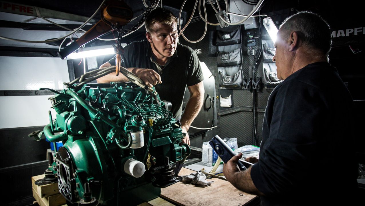 Two men standing close to a Volvo Penta engine