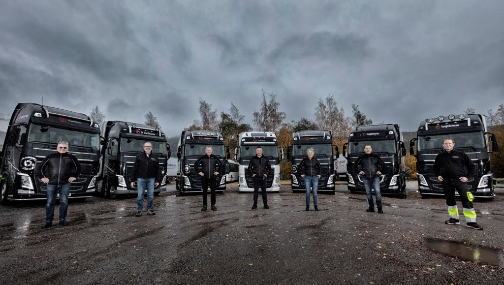 Noen av de ansatte lærerne med den flotte Volvo bilparken i bakgrunnen. 