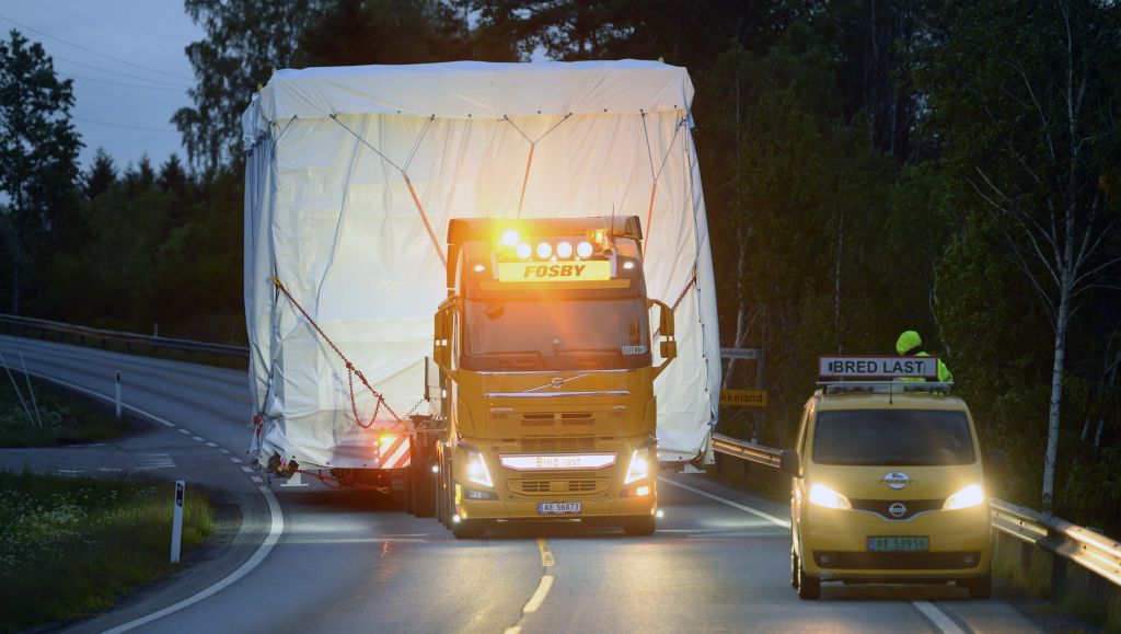 Fosby Kran sin gule Volvo FH16 ser liten ut med et stort koloss på hengeren. Foto. 