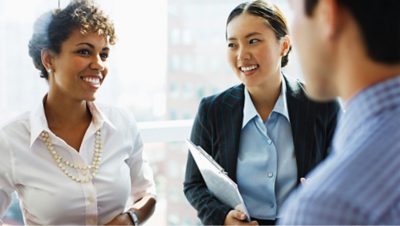 Two women and a man discussing salary and other benefits