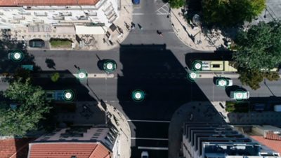 Intersecção onde gráficos mostram a comunicação entre veículos e semáforos, utilizando software de gestão de frota de ônibus.