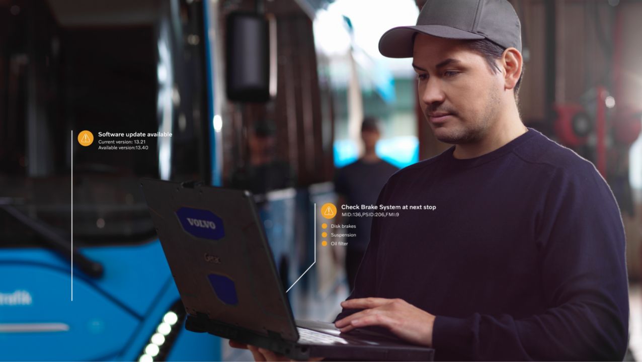 En bild som visar en verkstadstekniker med en bärbar dator framför en buss. Bilden har överlagrad grafik.