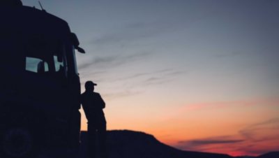 Volvo truck and man beside truck in sunset