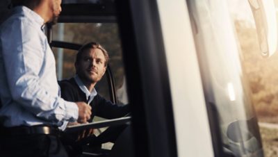  Male bus driver talking to a colleague on the bus