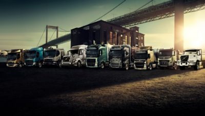 Trucks of different models in front of bridge