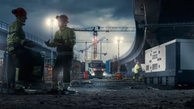 Dos trabajadores de Volvo Group conversando en un sitio de construcción de Volvo