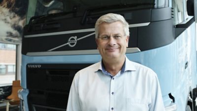 Човек стои пред Volvo FH