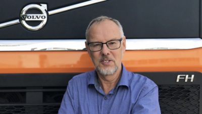 Vīrietis stāv Volvo FH priekšā