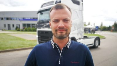 Човек стои пред Volvo FH