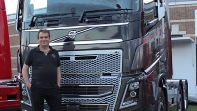 Човек стои пред Volvo FH