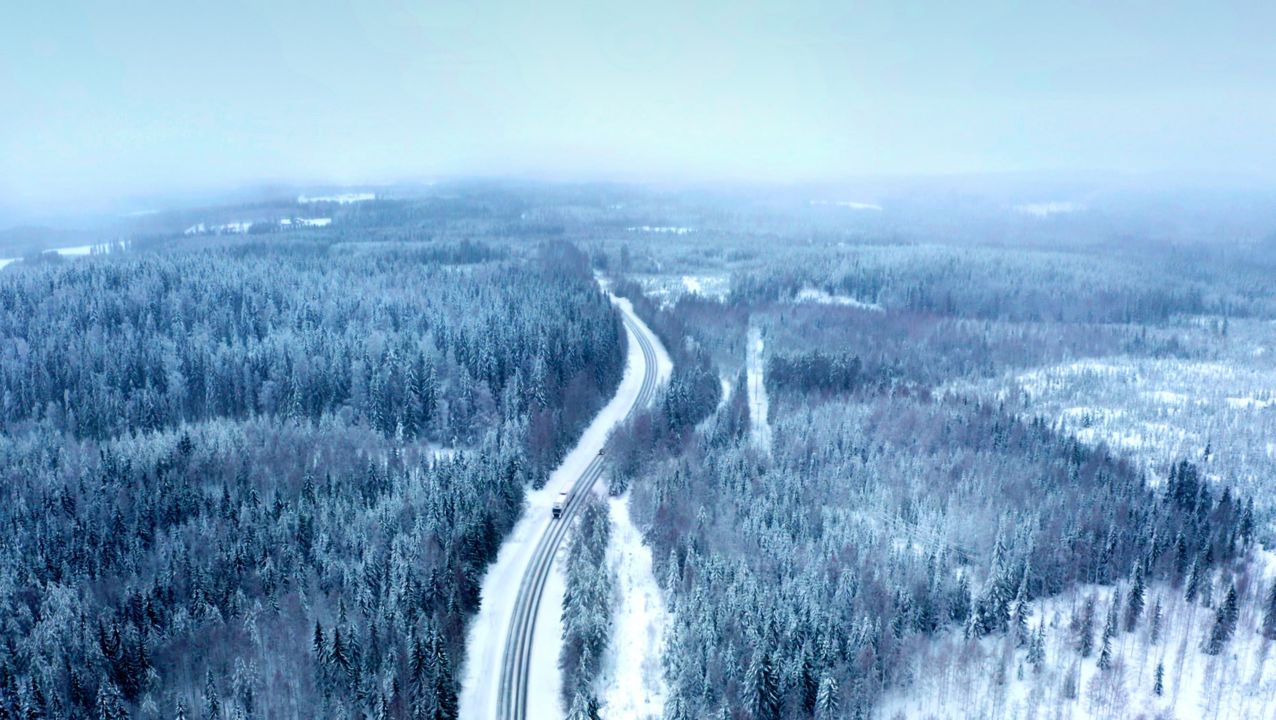 ถนนซึ่งปกคลุมไปด้วยหิมะที่ตัดผ่านผืนป่าทางตะวันออกของประเทศฟินแลนด์