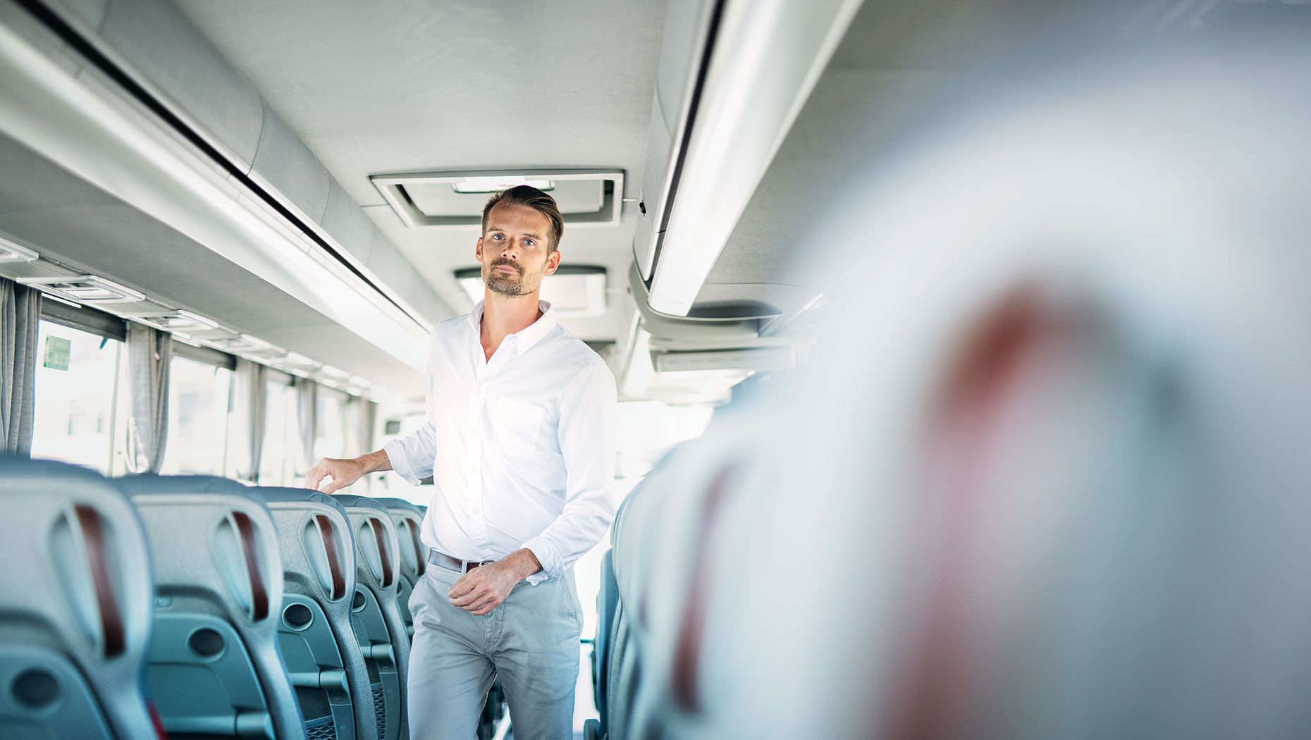 Karl Johansson geht in einem Volvo-Reisebus den Gang entlang