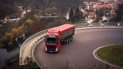 A Volvo truck on a winding, hillside road