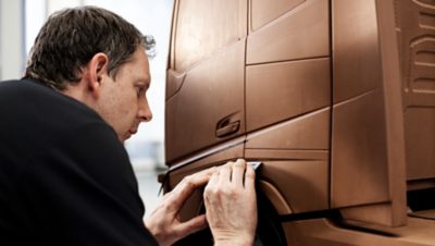 Volvo Group employee constructing a bronze colored model of a Volvo truck
