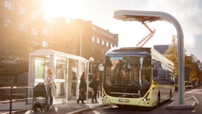 Future vision concept of a Volvo Group bus picking up passengers at a bus shelter