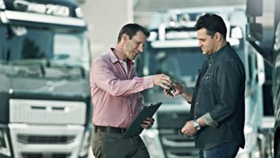 Volvo Group salesman handing over the key for a Volvo truck to a customer