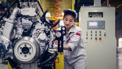 Une femme assemblant un moteur