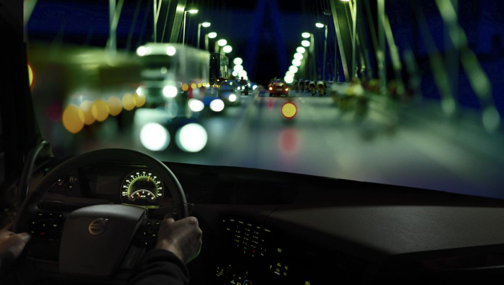 Eine stark befahrene Autobahn bei Nacht, von einem Lkw-Fahrerhaus aus gesehen