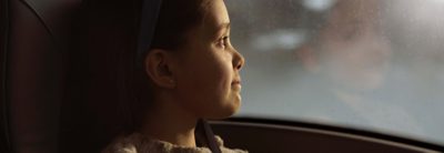  Girl with safety belt looking out of the bus window