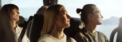 Three passengers seated in bus looking out of the window