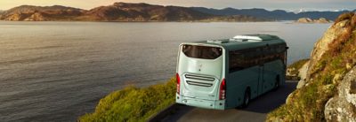  Turistbuss sett bakfra, på en kystvei. Havet i bakgrunnen