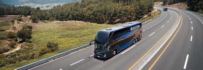 Volvo 9800 Double Decker visto desde la parte trasera conduciendo por una carretera a orillas del mar