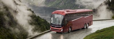 Buss på en vei med en fjord i bakgrunnen