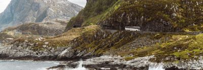 Autobus à étage sur une route avec fjord en arrière-plan