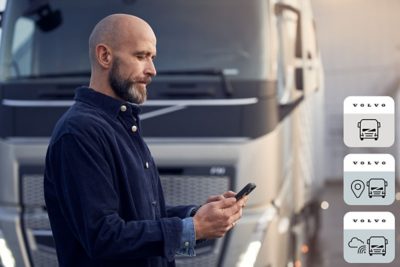 Driver with phone in front of truck                        