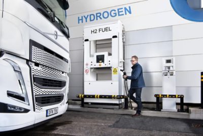 Person filling up a white Volvo truck with hydrogen fuel I Volvo Group