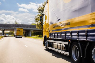 Foto van Joanne die in overall kippenbotjes uit haar trailer laadt.