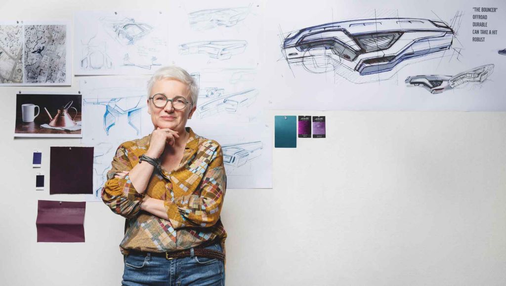 Карина Бистром, главен дизајнер за ентериер во Volvo Trucks застаната пред скици од дизајнот на Volvo FM и примероци во боја на ѕид