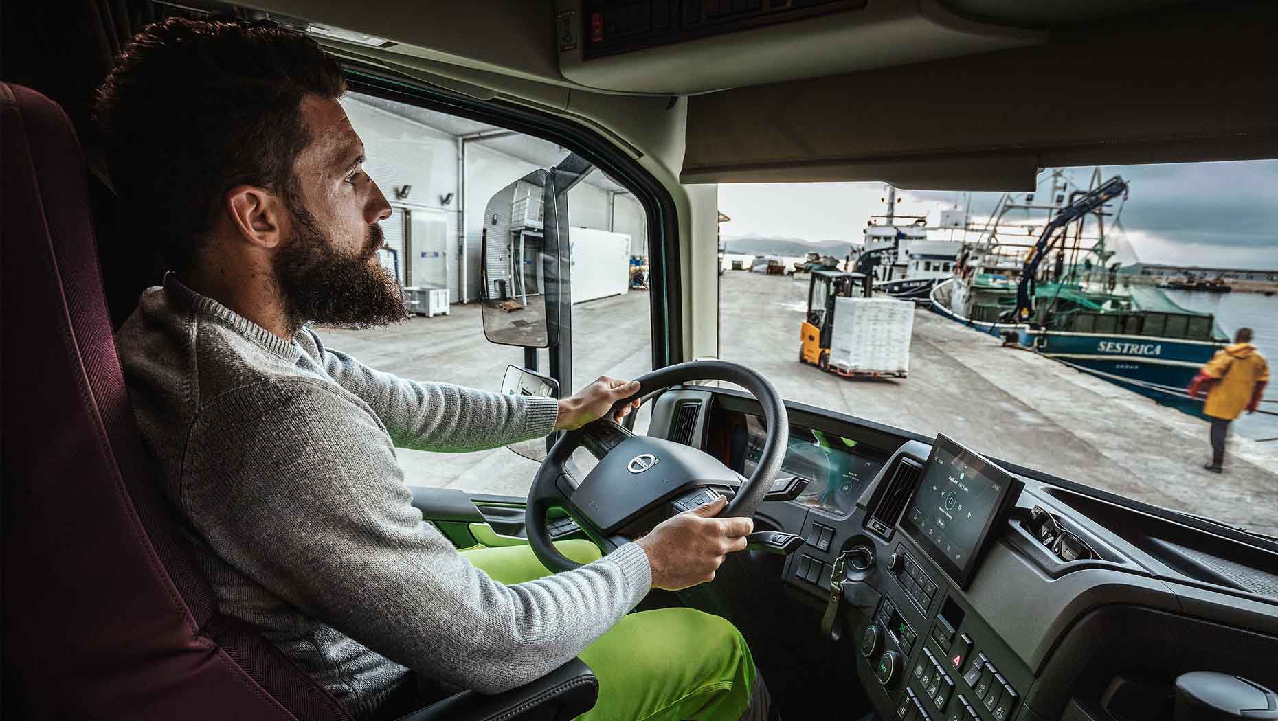 Um motorista na cabina do novo Volvo FH num porto