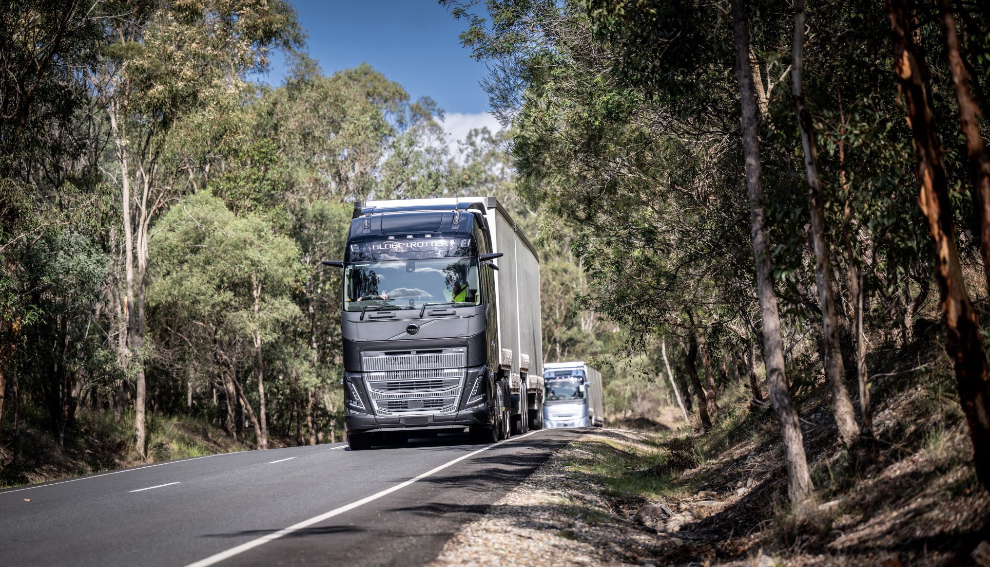 Two Volvo trucks driving on a road